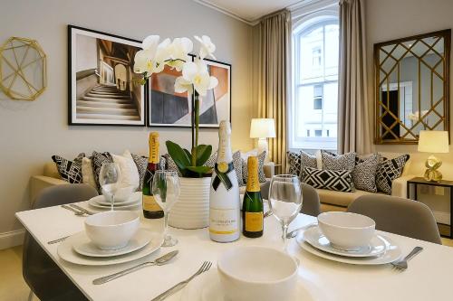 ein Esstisch mit Weinflaschen und Gläsern in der Unterkunft Premier 3 Bed Luxury Apartment in Covent Garden in London