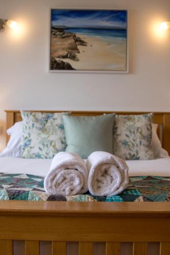 two towels sitting on top of a bed at Seascape at coed y berclas, luxury accommodation with stunning sea view in Llandegfan