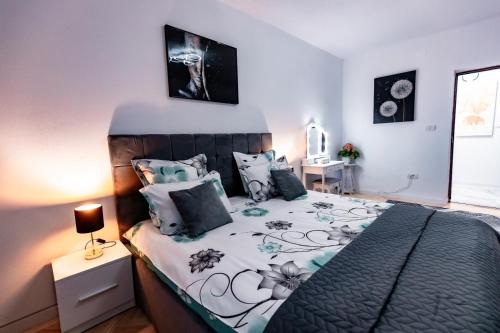 a bedroom with a bed with a black and white comforter at Luxury Riverside Apartment Băile Herculane in Băile Herculane