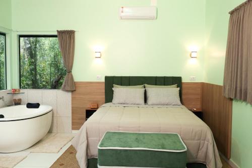 a bedroom with a bed and a bath tub and a tub at Pousada Kaporã in Bocaiúva do Sul