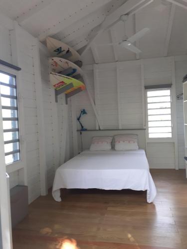 a bedroom with a bed in a white room at surf lodge in Deshaies