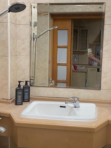 a bathroom sink with a shower and a mirror at Shanghai single room in Shanghai