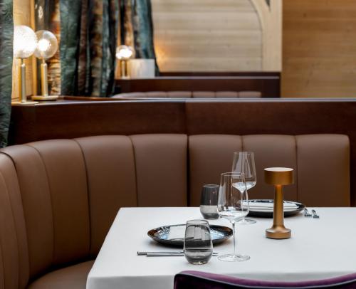 a table with wine glasses on it in a restaurant at HUUS QUELL by Appenzeller Huus in Gonten