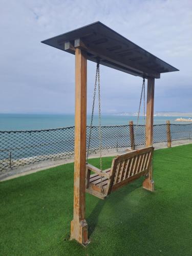 a swing with a roof on top of a beach at Cómoda Casa con vista al Mar en Manta in Manta
