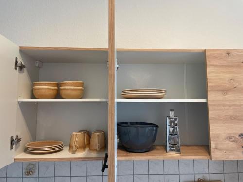 a kitchen cabinet with plates and bowls on it at Moderne Wohnung für 4 Personen in Zeitz