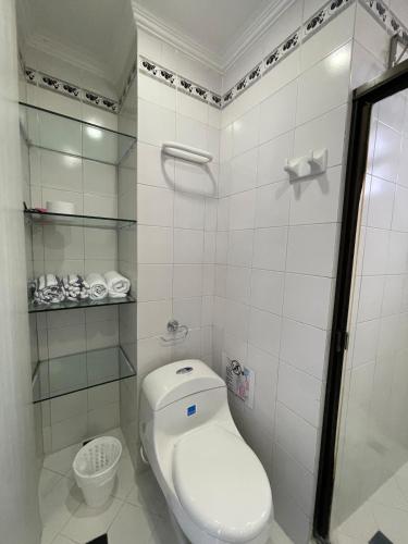 a white bathroom with a toilet and a shower at Loft in Cartagena with direct beach access in Cartagena de Indias
