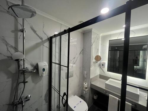 a bathroom with a shower and a toilet and a mirror at Side Zeugma Hotel - Adult Only 16 Plus in Side