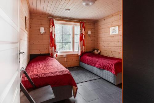 a small bedroom with two beds and a window at Beautiful house and sauna on the lake, 175 m2 in Lappeenranta