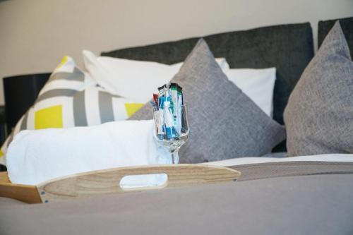 a wine glass on top of a bed with pillows at Castle View in Dudley
