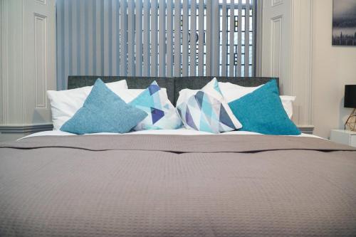 a bed with blue and white pillows on it at Castle View in Dudley