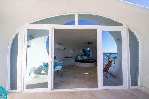 Habitación con una gran puerta de cristal que conduce a un baño. en Shark Studio Retreat at Swan Villas - Gold Standard Certified, en Maya Beach
