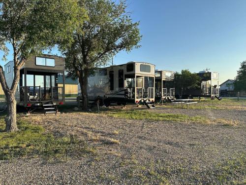 an rv parked in a field next to a tree at Prairie Dog Perch Tiny Home in Interior