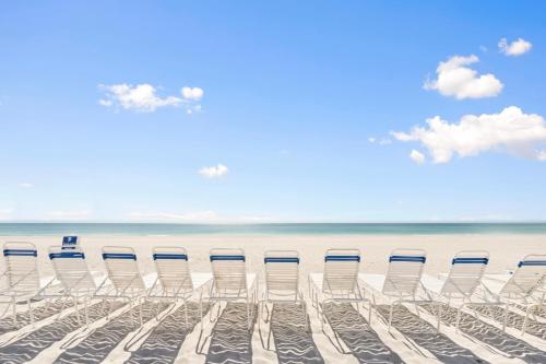 Un grupo de sillas sentadas en una playa en Gulf Tides of Longboat Key, en Longboat Key