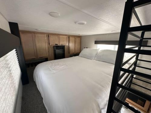 a bedroom with a large white bed and a ladder at Coyote Crossing Tiny Home in Interior