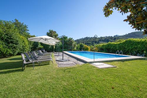 una piscina con sedie e un ombrellone di Recantos na Portela ad Amares