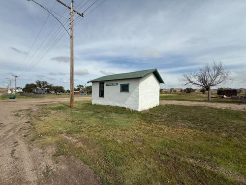 a small white building on the side of a road at Grasshopper Flats RV Pad in Interior