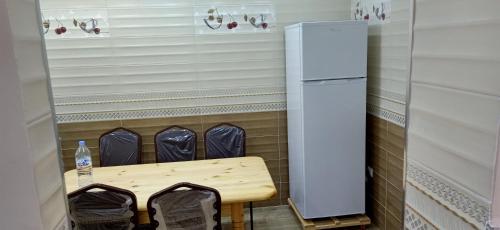 a small kitchen with a table and a refrigerator at vacdellys in Boumerdes