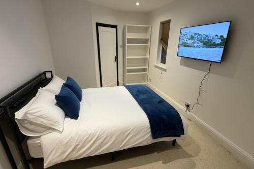a bedroom with a bed with a tv on the wall at Downtown Loughborough Escape 3BR Flat for 6 Guests in Loughborough