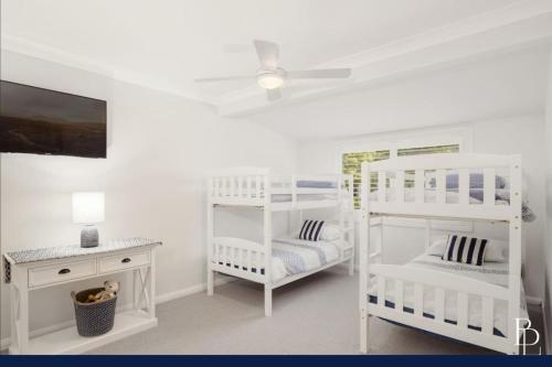 BeaumontにあるParadisoの白いベッドルーム(二段ベッド2台、テーブル付)