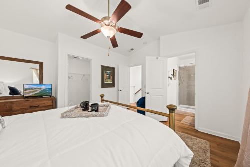 a white bedroom with a ceiling fan and a bed at Southern Oak Cottage in Ladson