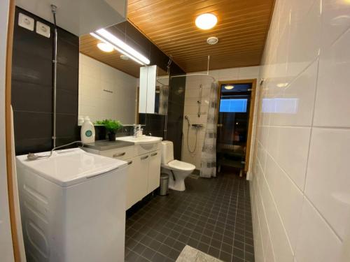 a bathroom with a white sink and a toilet at Modern Apartment for 2 with Sauna in Kemi