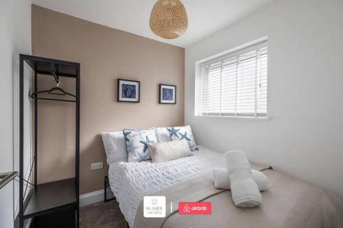 a bedroom with a bed and a window at Beachside Retreat l Sun Terrace l Hot Tub l Free Parking l Seaside Escapes Short Lets & Serviced Accommodation in Bournemouth