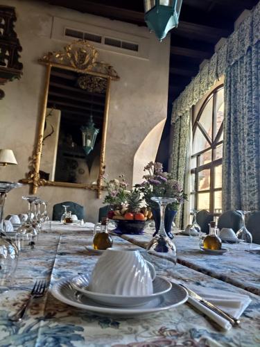 ein Esszimmer mit einem Tisch mit Tellern und einem Spiegel in der Unterkunft El Palacio de San Benito in Cazalla de la Sierra
