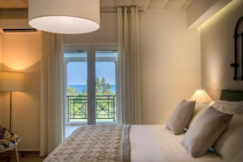 a bedroom with a bed and a large window at Rivazzurra Beachfront Luxury Villa in Lithakia