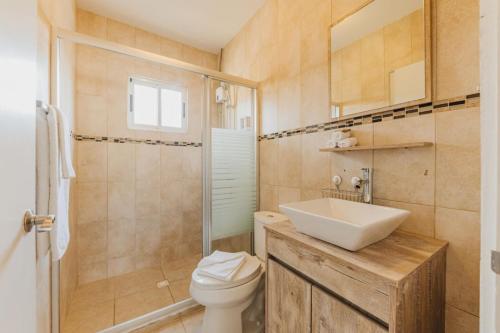 a bathroom with a toilet and a sink and a shower at Charming hideaway 2 min to Beach in Palm-Eagle Beach