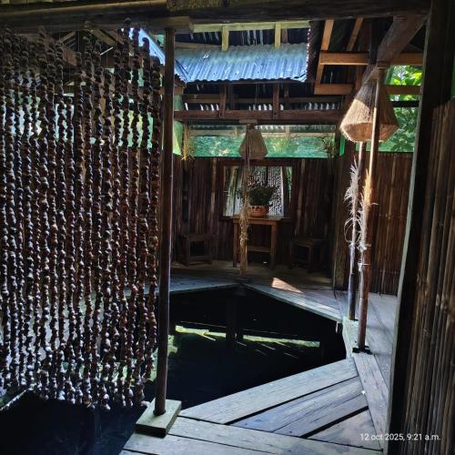 a swimming pool in a house with a wooden floor at Reserva Ecologica Nanciyaga in Catemaco
