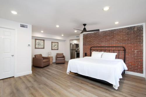 una camera da letto con un letto bianco e un muro di mattoni di Cedars Peak Downtown 2 Condos a Sevierville