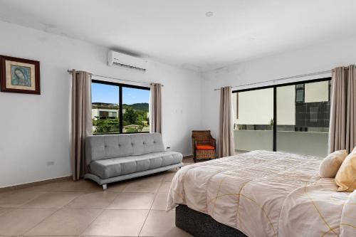 a bedroom with a bed and a couch and windows at Casa Oasis B-Nayar Gated, Beach Club, Free Shuttle in Cruz de Huanacaxtle