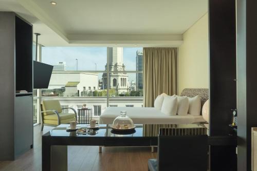a hotel room with a bed and a view of a city at NH Collection Buenos Aires Centro Histórico in Buenos Aires