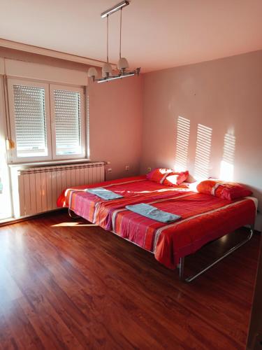 1 dormitorio con 1 cama grande con sábanas rojas en Radonjic, en Káty