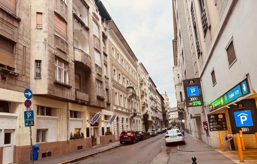 una calle de la ciudad con edificios y coches aparcados en la calle en Opera Central Stay, en Budapest