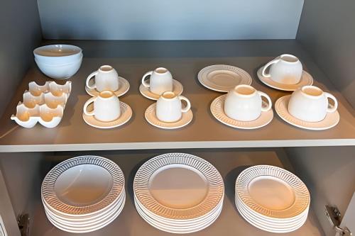 a shelf filled with plates and cups and dishes at Vista espetacular, piscina e banheira no quarto! in Maria da Fé