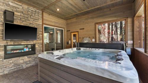 a jacuzzi tub in a room with a tv at South Lake Escape Indoor Pool plus Movie Theater in Bijou