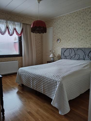 a bedroom with a bed with a white bedspread at Villa Tolonen in Talosenkylä