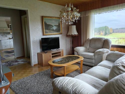 een woonkamer met een bank en een tafel bij Villa Tolonen in Talosenkylä