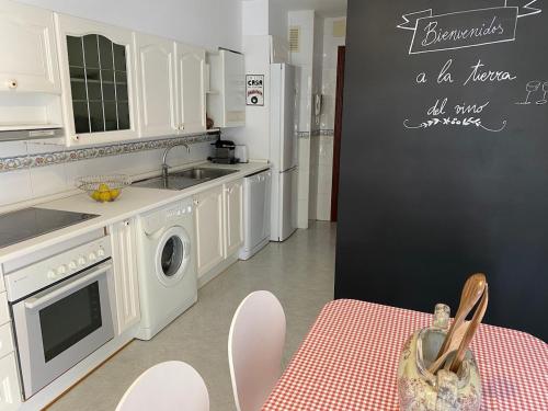 a kitchen with white cabinets and a sink and a stove at Spacious, cozy apartment with garden in Logroño