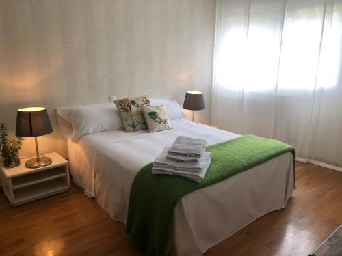 a bedroom with a bed with a green blanket on it at Spacious, cozy apartment with garden in Logroño
