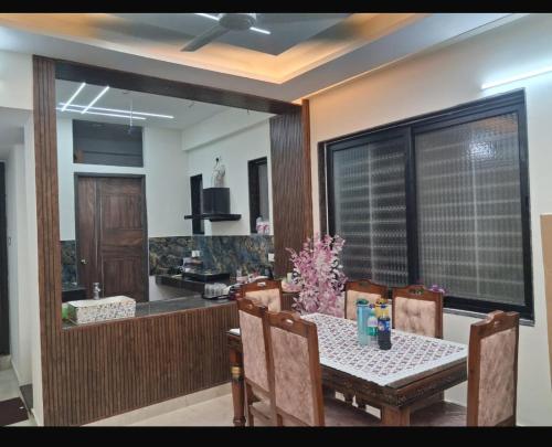 a dining room with a table and a kitchen at YR Heights Home Stay in Hyderabad