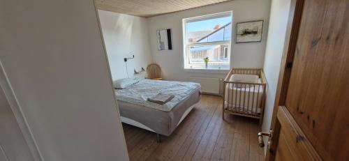 a small bedroom with a bed and a window at Fihermans House Joanna in Hirtshals