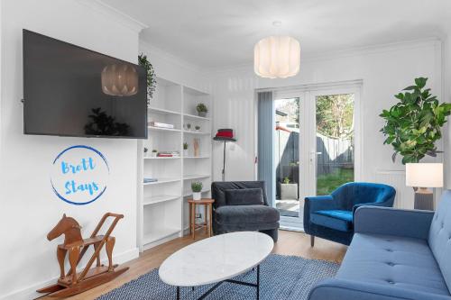 a living room with blue chairs and a tv at Brett Stays - Fast WiFi - Modern Amenities - Smart TV - Sleeps 7 in Avonmouth