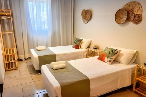 ein Zimmer mit drei Betten und einem Fenster in der Unterkunft Ap 101 - Apartamento no centro da cidade in Maria da Fé