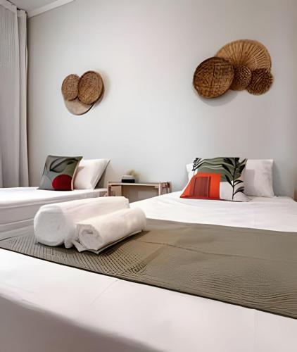 a bedroom with two beds with towels on them at Ap 101 - Apartamento no centro da cidade in Maria da Fé