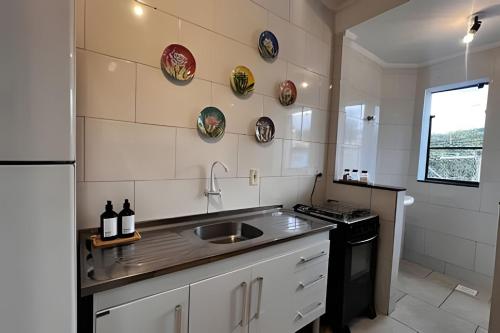 a kitchen with a sink and a stove at Ap 101 - Apartamento no centro da cidade in Maria da Fé