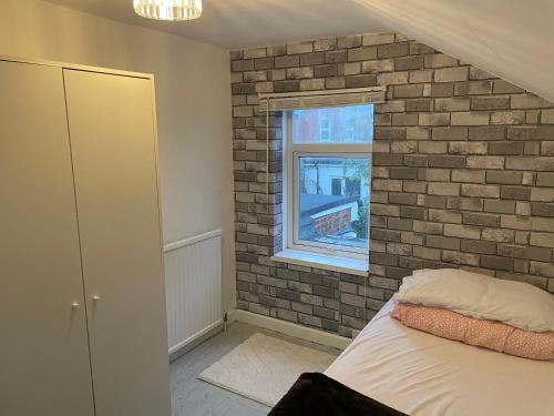 a bedroom with a brick wall and a bed at 3 Bed House in Reading Area in Reading
