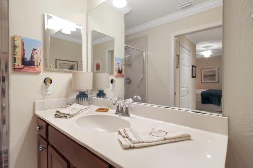 a bathroom with a sink and a large mirror at Resort style lakefront condo in River Strand - Golf membership included - Florida Sunshine in Marsh Island