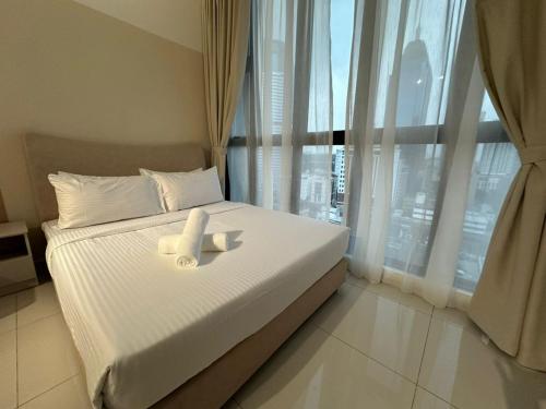 a bedroom with a bed with white sheets and a window at Majestic Residence Klcc by Like Home in Kuala Lumpur